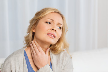 Image showing unhappy woman suffering from throat pain at home