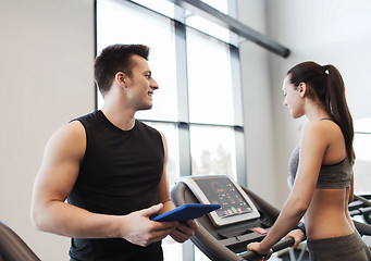 Image showing happy woman with trainer on treadmill in gym