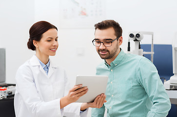 Image showing optician with tablet pc and patient at eye clinic