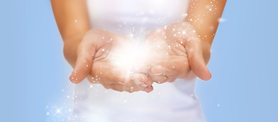 Image showing magic twinkles or fairy dust on female hands