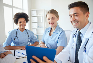 Image showing happy doctors with tablet pc meeting at hospital