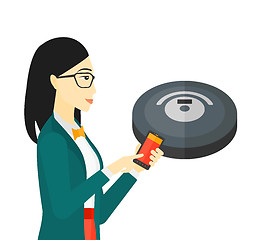 Image showing Woman with robot vacuum cleaner.