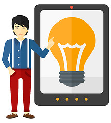 Image showing Man pointing at tablet computer with light bulb on screen.