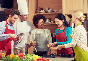 Image showing happy friends and chef cook cooking in kitchen