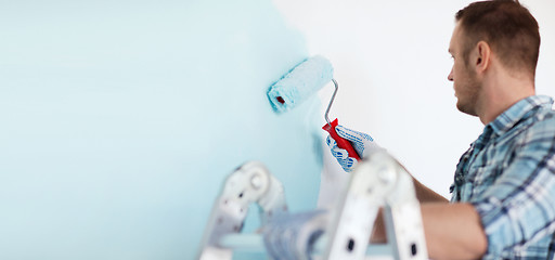 Image showing close up of male in gloves holding painting roller