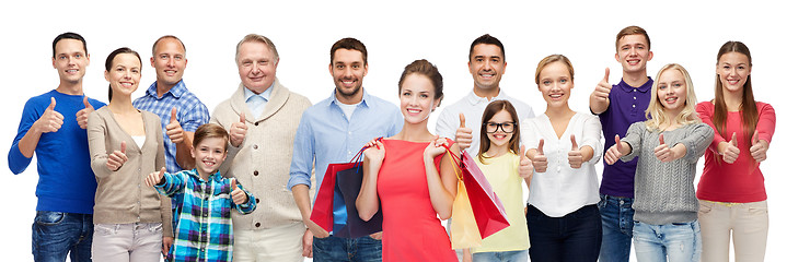 Image showing happy people with shopping bags showing thumbs up