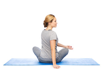 Image showing woman making yoga in twist pose on mat