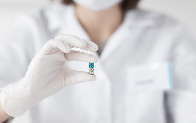 Image showing close up of scientist holding pill in lab