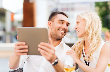 Image showing happy couple with tablet pc at restaurant lounge