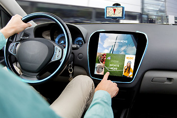 Image showing close up of man driving car with news application