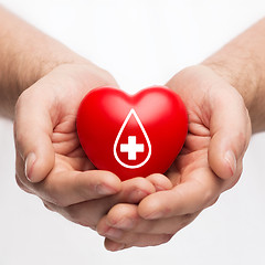 Image showing male hands holding red heart with donor sign