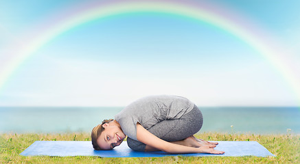 Image showing happy woman making yoga in child pose on mat