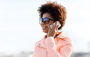 Image showing smiling african american woman with smartphone