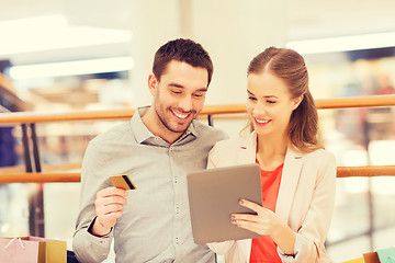 Image showing couple with tablet pc and shopping bags in mall