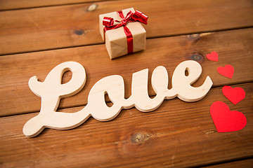 Image showing close up of word love with gift box and red hearts