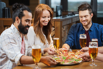 Image showing friends eating pizza with beer at restaurant