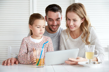 Image showing happy family with tablet pc at restaurant