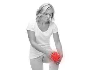 Image showing unhappy woman suffering from pain in leg