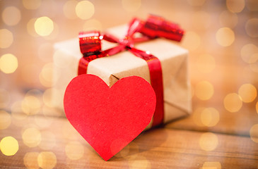 Image showing close up of gift box and heart shaped note on wood