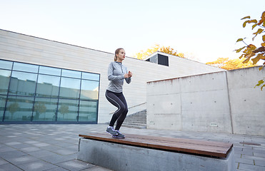 Image showing woman exercising on bench outdoors