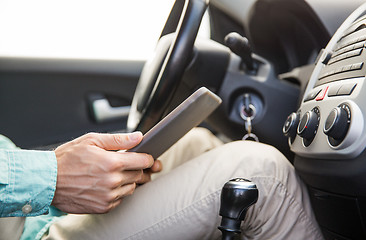 Image showing close up of young man with tablet pc driving car