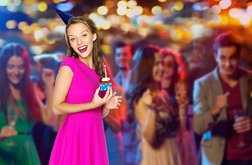 Image showing happy woman with birthday cupcake at night club