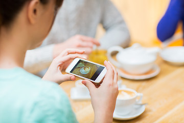 Image showing close up of woman smartphone picturing coffee cup