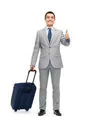 Image showing happy businessman in suit with travel bag