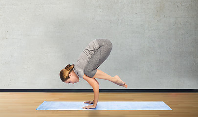 Image showing woman making yoga in crane pose on mat