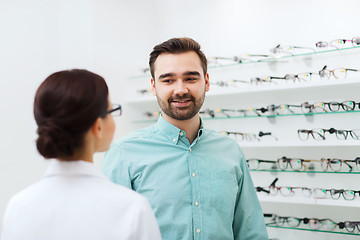 Image showing optician showing glasses to man at optics store