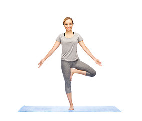 Image showing woman making yoga in tree pose on mat
