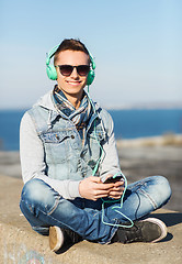 Image showing happy young man in headphones with smartphone