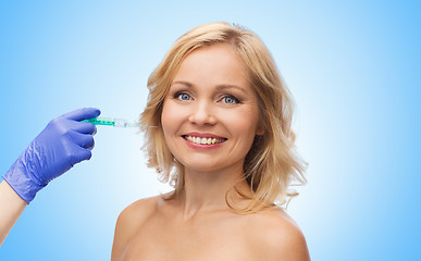 Image showing happy woman face and beautician hand with syringe