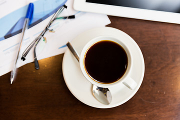 Image showing close up of coffee, charts and tablet pc on table