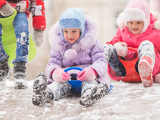 Image showing Two cheerful girls are rolling hills with each other with icy hill