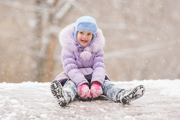 Image showing Joyful child slides down the icy hill
