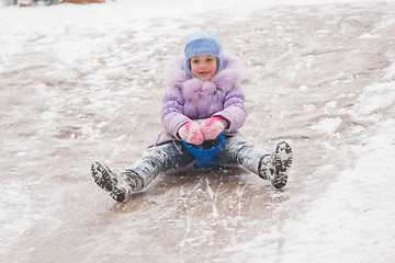 Image showing Five-year girl rolls on in the middle of the ice slides