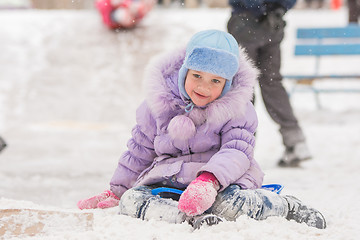 Image showing Joyful five years girl has slipped from the icy hill