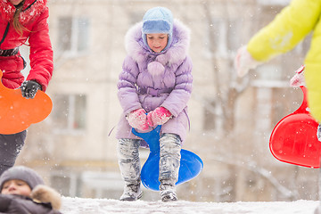 Image showing Funny five-year girl runs up to roll down a icy hill