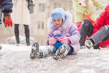 Image showing Five-year girl is rolling a frozen hill