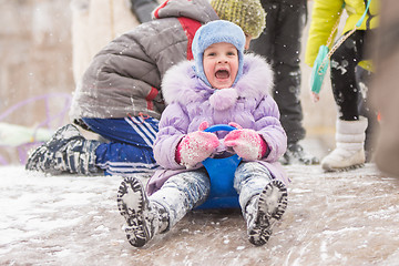 Image showing Five-year girl fun screaming slides down the icy hill