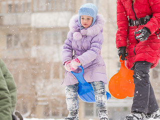 Image showing Five-year girl on top of an icy hill preparing to move out down