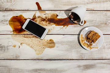 Image showing Cup of coffee spilled on wooden table