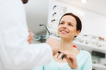 Image showing woman and optician showing glasses at optics store