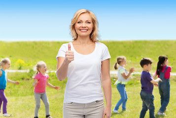 Image showing woman showing thumbs up over group of little kids