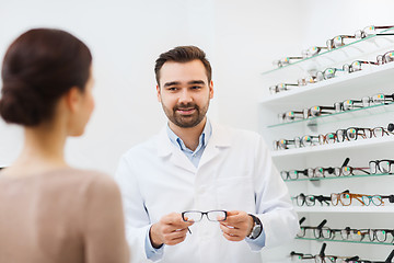 Image showing woman and optician showing glasses at optics store