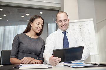 Image showing smiling businesspeople with tablet pc in office