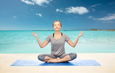 Image showing woman making yoga meditation in lotus pose on mat