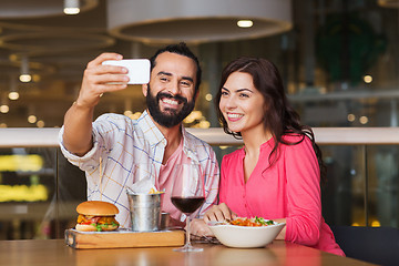 Image showing couple taking selfie by smartphone at restaurant