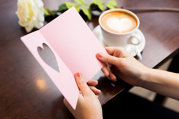 Image showing close up of woman reading greeting card and coffee